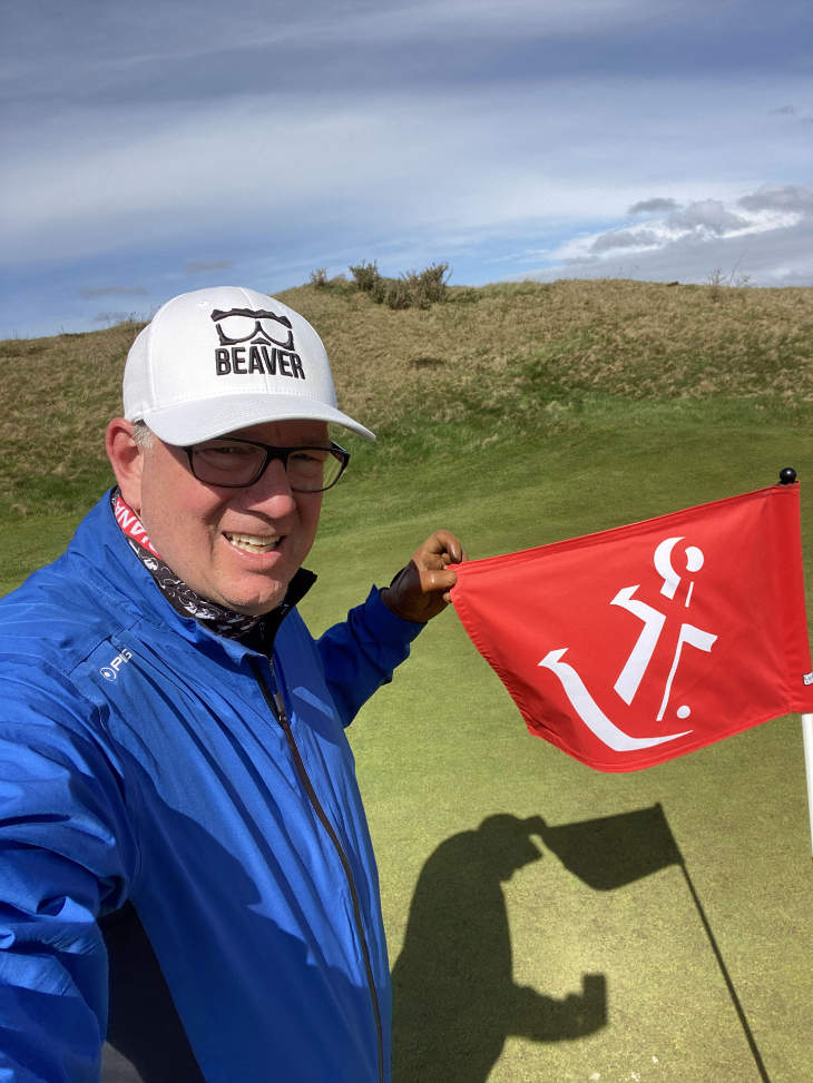 Golfer Dirk Beyer mit einer Golf-Fahne auf einem sylter Golfplatz