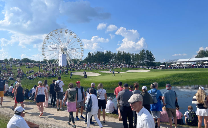 Viele Menschen und ein Riesenrad auf einem Golfplatz