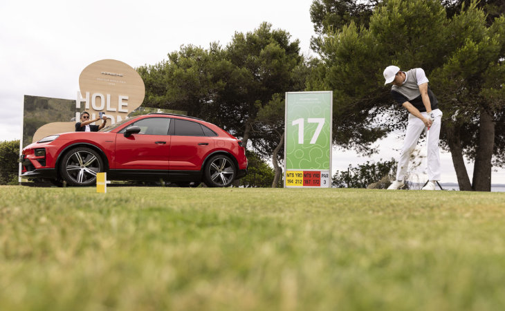 Ein Golfer neben einem Elektroauto auf einem Golfplatz