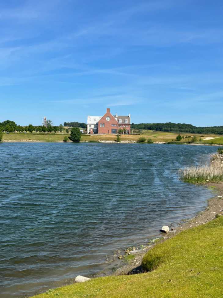 Ein See und ein Clubhaus auf einem Golfplatz