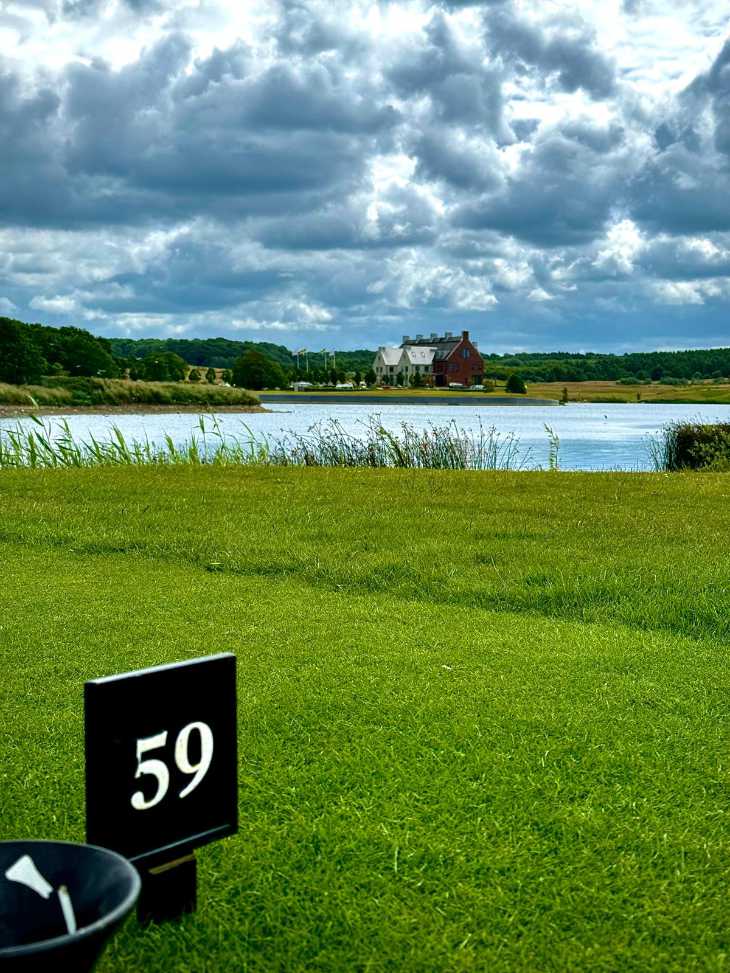 Ein See und ein Clubhaus auf einem Golfplatz