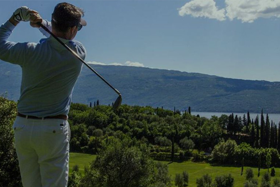 Ein Golfer schlägt vor dem Gardasee ab