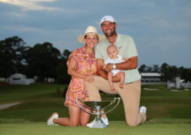 Scottie Scheffler präsentiert den FedExCup mit seiner Frau und seinem Kind.