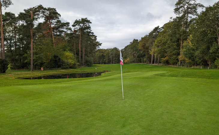 Ein Wasserhindernis und eine Fahne auf einem Golfplatz