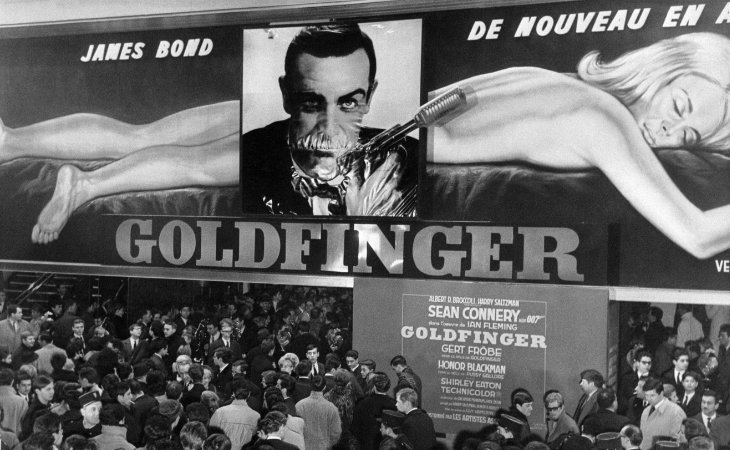 Viele Kinobesucher unter dem Filmposter des Films Goldfinger