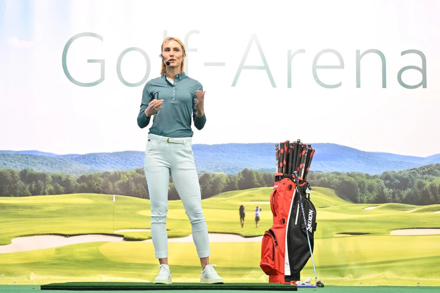 Eine Frau hält einen Vortrag auf einer Golfmesse