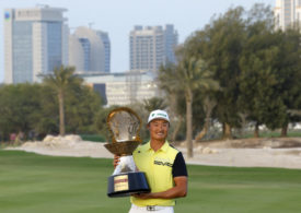 Li Haotong präsentiert die Trophäe des Qatar Masters